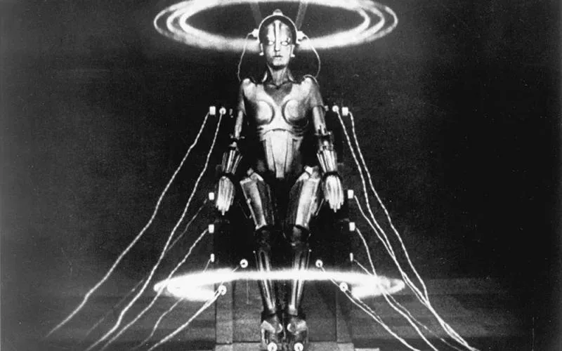 A high-contrast still from the film Metropolis showing a human-like machine figure surrounded by electrical rings.